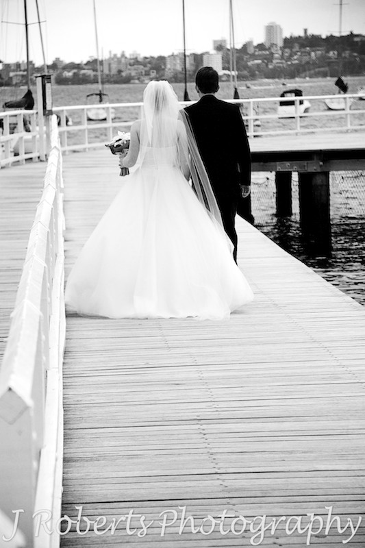 B&W of wedding couple walking away along the boardwalk at Balmoral Baths - wedding photography sydney